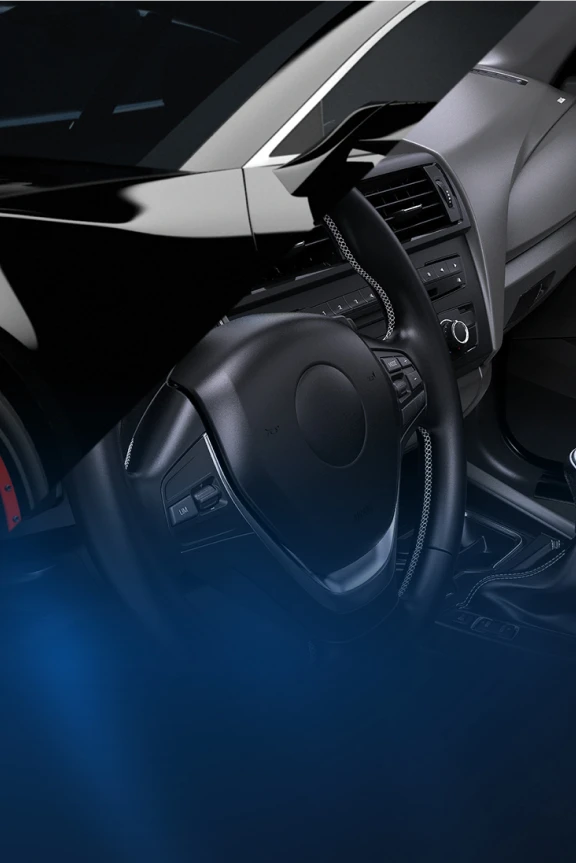 Detailansicht eines schwarzen Sportwagens mit offenem Innenraum, Lenkrad und Armaturen im Fokus. 